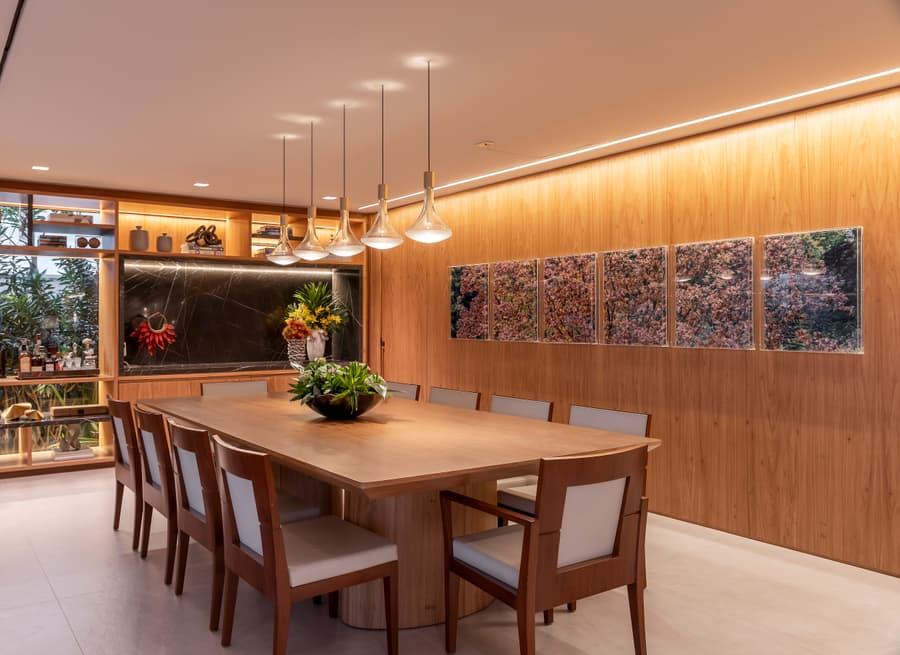 Sala de jantar com painel de madeira e a adega envidraçada ao fundo